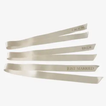 Gepersonaliseerd satijnlint 2,5 cm breed en 70 cm lang in ivoor met gouden opdruk, lettertype 2, teksten Groom, Bride en Just Married.