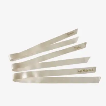 Gepersonaliseerd satijnlint 2,5 cm breed en 70 cm lang in ivoor met gouden opdruk, lettertype 3, teksten Groom, Bride en Just Married.