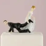 Porseleinen taarttopper met bruid die bruidegom meesleept, humoristisch bruidspaar ontwerp